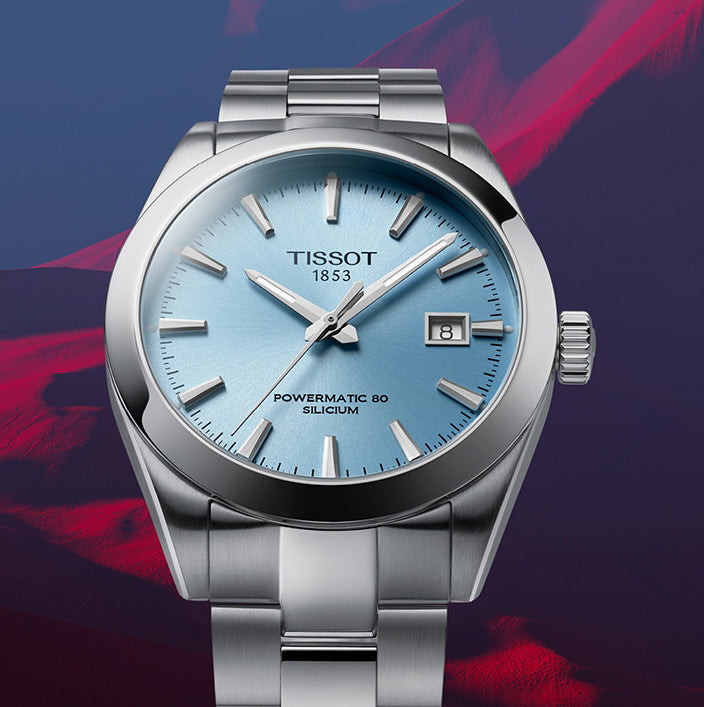 Tissot watch with blue dial and silver case on a colorful background